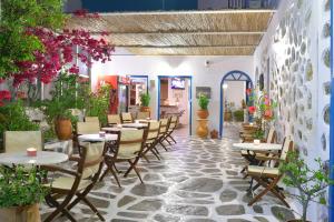 a restaurant with tables and chairs and flowers at Hotel Nazos 1 in Mýkonos City