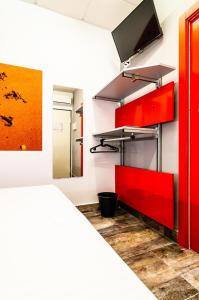 Habitación con armarios rojos y TV en la pared. en ALIOCIO en Palos de la Frontera