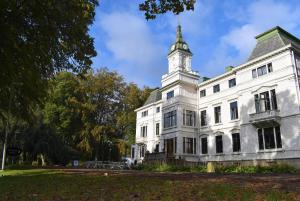 a white building with a clock tower on top of it at STF Wendelsberg Hotel & Hostel in Mölnlycke