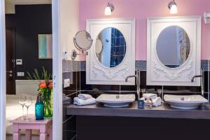 a bathroom with two sinks and two mirrors at Frédéric Carrion - Cuisine, Hôtel & Spa in Viré +27 photos