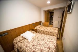 a hotel room with two beds and a mirror at Hostal Caballeros in Soria