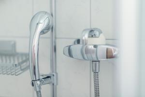a shower head and a faucet in a bathroom at Berghaus Diavolezza in Berninahäuser