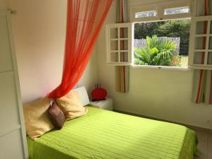 een slaapkamer met een groen bed en een raam bij Villa des Stars xtelx0690x07xx1415xx in Saint-François