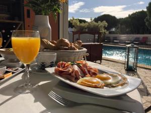 a plate of breakfast food and a glass of orange juice at Entre 2 eaux in Marseillan