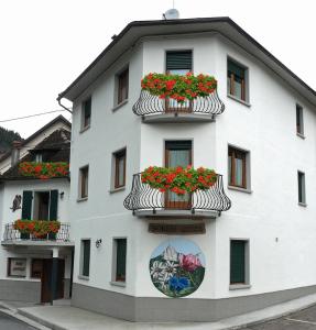 a white building with flowerpots on the side of it at Casa Screm - Appartamenti e Camere in Rigolato