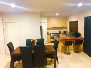 a kitchen and dining room with a table and chairs at Golf View Charm in Craigieburn