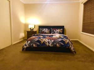 a bedroom with a bed with a dog laying on it at Golf View Charm in Craigieburn