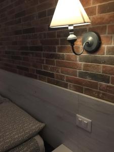 een lamp op een bakstenen muur naast een bed bij Bologna Centrale Stanze in Bologna