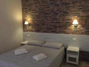 a bedroom with a bed and a brick wall at Bologna Centrale Stanze in Bologna