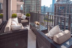 a balcony with wicker chairs and tables on a building at Elite Royal Apartment - Supreme in Dubai