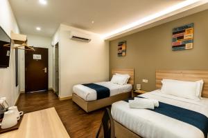 En eller flere senge i et værelse på Orange Hotel Kota Kemuning @ Shah Alam