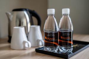 two bottles of water sitting on a black tray at Orange Hotel Kota Kemuning @ Shah Alam in Shah Alam