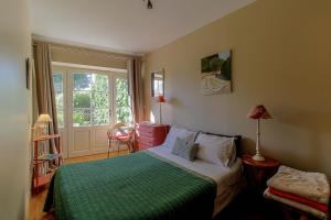 1 dormitorio con 1 cama con manta verde en La Madeleine, en La Jarrie