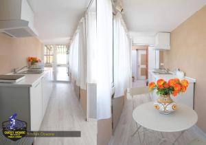 Una cocina con una mesa con un jarrón de flores encima. en Guest House Bike & Relax Finale Ligure, en Finale Ligure