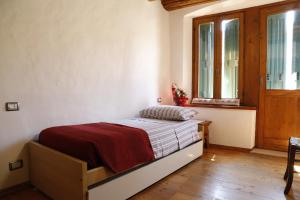 Un dormitorio con una cama en una habitación con ventana. en Luzzo 15, en Feltre