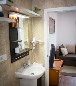 a bathroom with a sink and a toilet and a couch at Apartamento Gloria in Polop