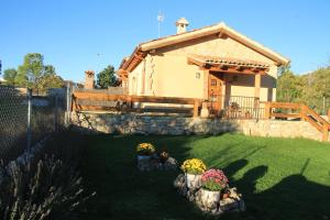 Una pequeña casa con algunas flores en un patio. en Las casitas de La Velilla, en Pedraza-Segovia