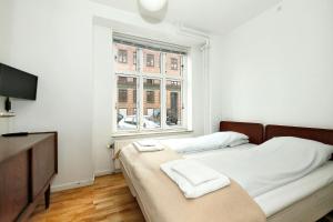 Hotel 9 små hjem في كوبنهاغن: غرفة نوم بسريرين ونافذة