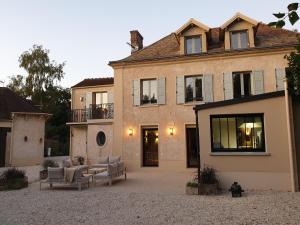 una casa grande con 2 sofás en un patio en Domaine les Bruyères, en Gambais