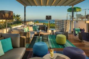 a patio with couches and tables on a balcony at El Llorenc Parc de la Mar - Adults Only (+16) in Palma de Mallorca