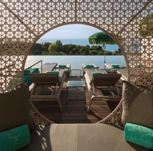 a patio with chairs and tables and a view of the water at El Llorenc Parc de la Mar - Adults Only (+16) in Palma de Mallorca