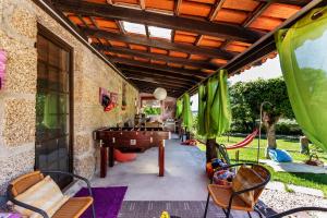een terras met een pingpongtafel en stoelen bij Casa do Casal in Guimarães