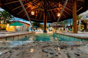 uma piscina num resort com guarda-sol e cadeiras em Rio das Pedras Thermas Hotel em Caldas Novas