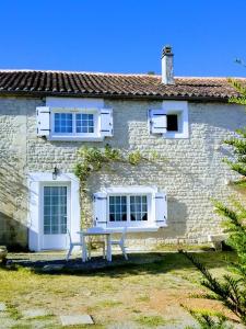 ein Steinhaus mit einer Bank davor in der Unterkunft Châtellenie d Ardennes in Fontenay-le-Comte