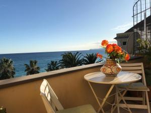 un tavolo con un vaso di fiori sul balcone di Guest House Bike & Relax Finale Ligure a Finale Ligure