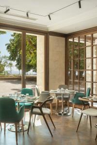 a dining room with tables and chairs and windows at El Llorenc Parc de la Mar - Adults Only (+16) in Palma de Mallorca