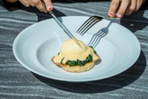 a person holding a white plate with a piece of food at El Llorenc Parc de la Mar - Adults Only (+16) in Palma de Mallorca