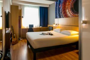 a hotel room with a large white bed in it at ibis Genève Petit Lancy in Geneva