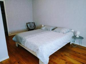 a bedroom with a bed with a white comforter at Châtellenie d Ardennes in Fontenay-le-Comte +3 photos