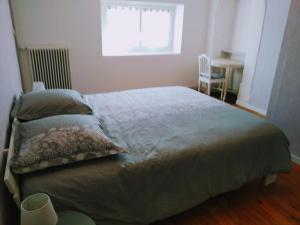 1 dormitorio con 1 cama, ventana y mesa en Châtellenie d Ardennes, en Fontenay-le-Comte