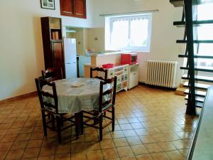 a kitchen with a table and chairs and a refrigerator at Châtellenie d Ardennes in Fontenay-le-Comte