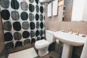 a bathroom with a toilet and a sink at Milhouse Hostel Hipo in Buenos Aires