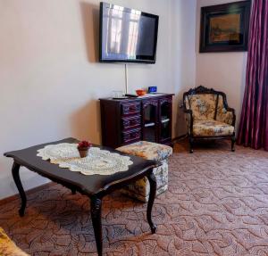 a living room with a table and a chair at Penzión pod hradom Gelnica in Gelnica