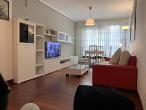 a living room with a red couch and a tv at Apartamento en Bilbao con Garaje opcional in Bilbao