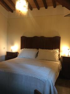 a bedroom with a large bed with white sheets and two lamps at VILLA Podere IL GIARDINO in Castiglion Fiorentino +44 photos