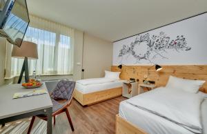 a hotel room with two beds and a desk at Ringhotel Gasthof Hasen in Herrenberg