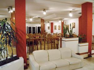 a living room with a white couch and a restaurant at Hotel Morales in San Clemente del Tuyú