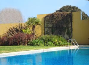 a swimming pool in front of a house and a building at Hotel Morales in San Clemente del Tuyú
