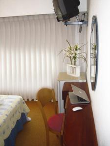 a bedroom with a desk with a laptop computer on it at Hotel Morales in San Clemente del Tuyú