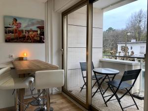 a room with a table and chairs and a window at Triangle d’or in Le Touquet-Paris-Plage