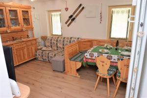 a living room with a table and a couch at Cësa Valeria e Cësa Giulio in Campitello di Fassa