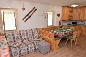 a living room with a couch and a table at Cësa Valeria e Cësa Giulio in Campitello di Fassa