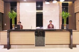 two women sitting at a reception desk in a lobby at Mida Hotel Ngamwongwan - SHA Plus in Nonthaburi +50 photos