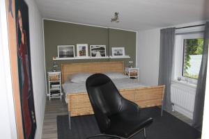 a bedroom with a bed and a black chair at 5 FeWo's Harztraum in Innenstadt mit kostenlosem Parkplatz von Harztraveler in Wernigerode
