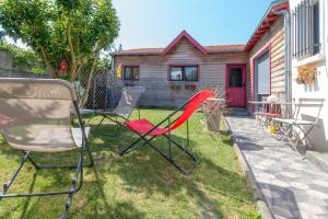 een groep stoelen in het gras voor een huis bij L'Escale Marine - Couette et Café in La Rochelle