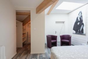 een slaapkamer met 2 paarse stoelen en een bed bij Grand duplex au calme en centre-ville in Villefranche-sur-Saône